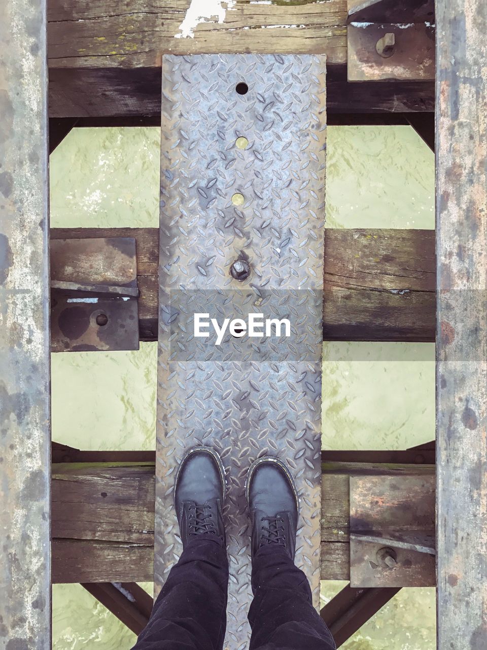 Low section of man standing on railway bridge over river