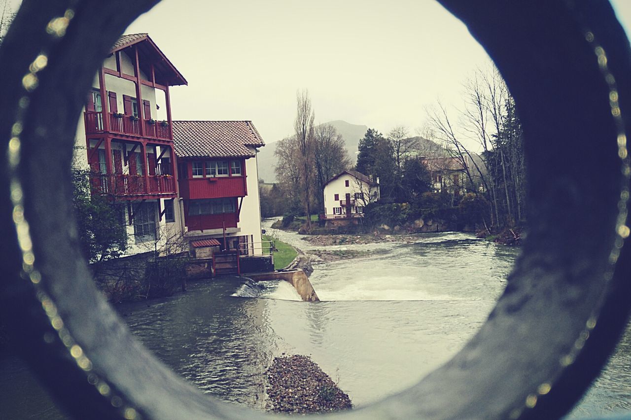 Stream by houses seen through hole