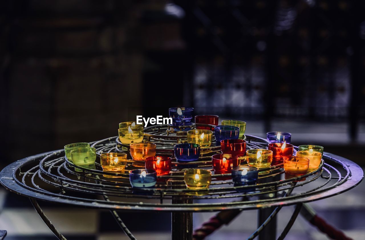 Illuminated tea light candles on metal at church