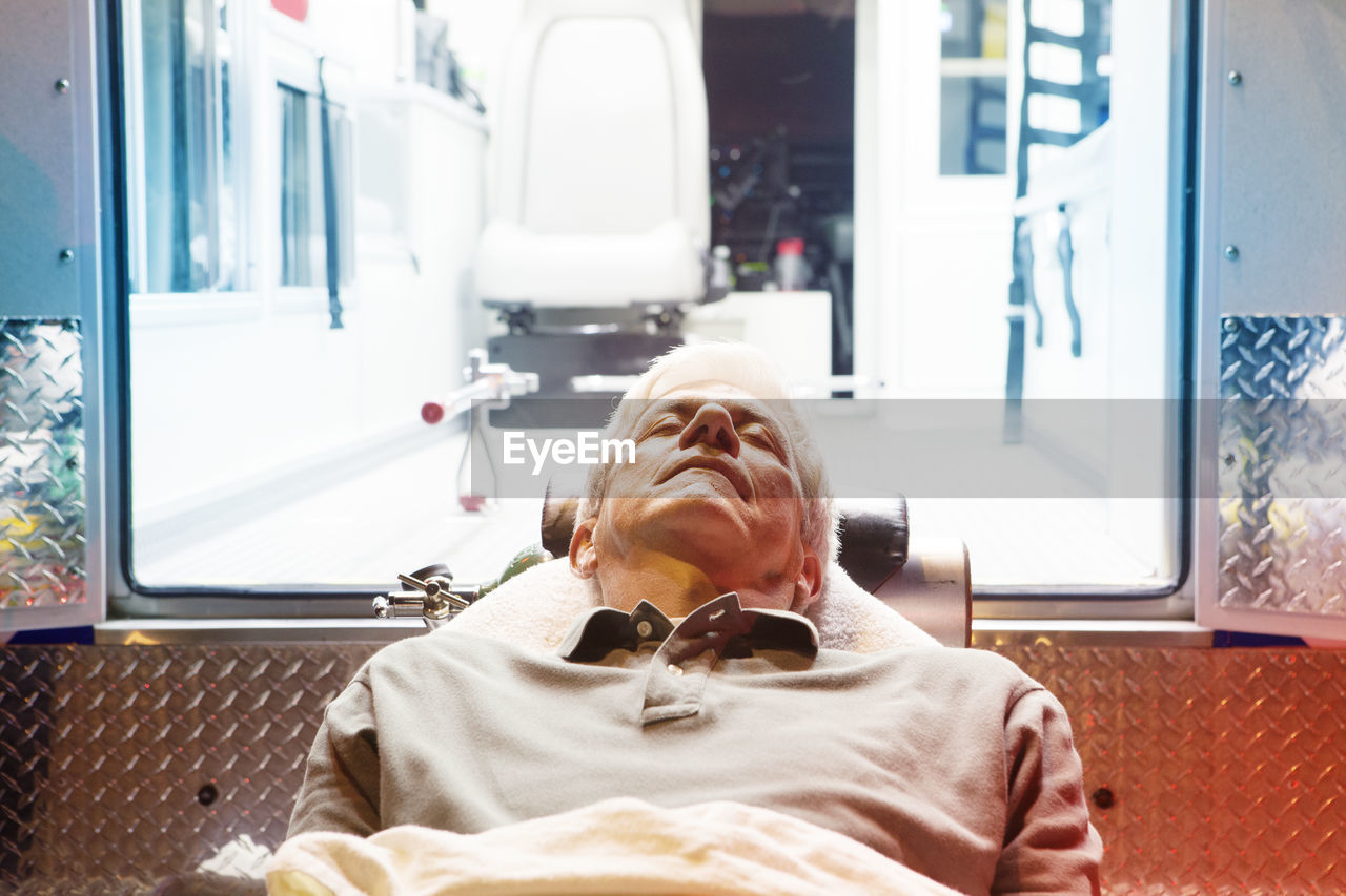 Close-up of patient lying on hospital gurney by ambulance