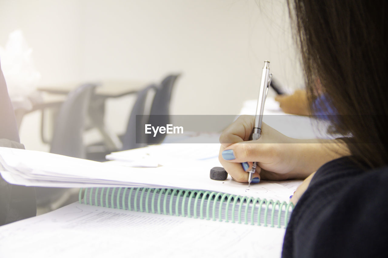 Hands university student study, quiz, test, or exam from teacher in large lecture classroom/ school.