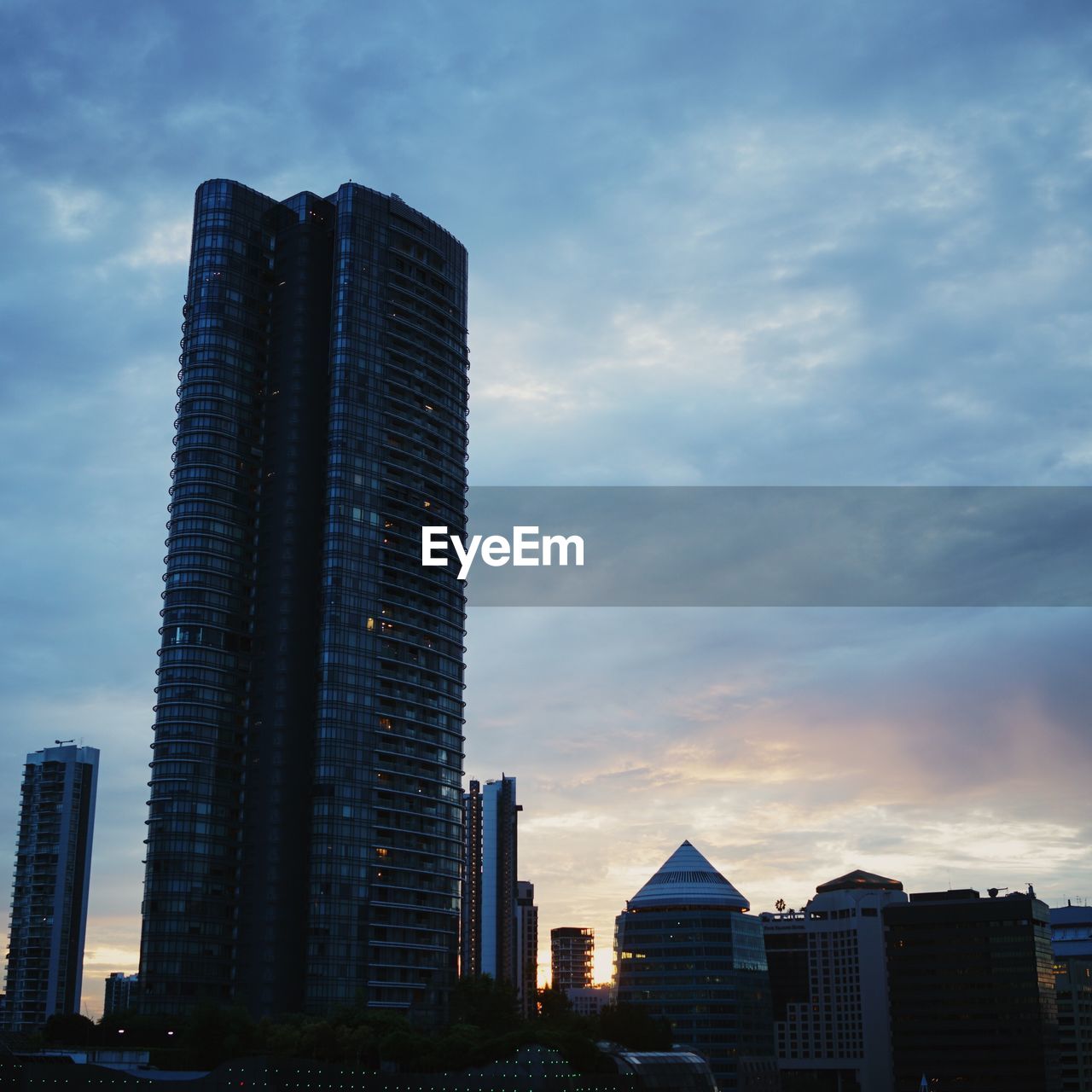 Buildings in city against sky at dusk