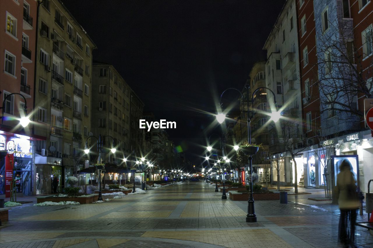 Street amidst buildings against sky in city