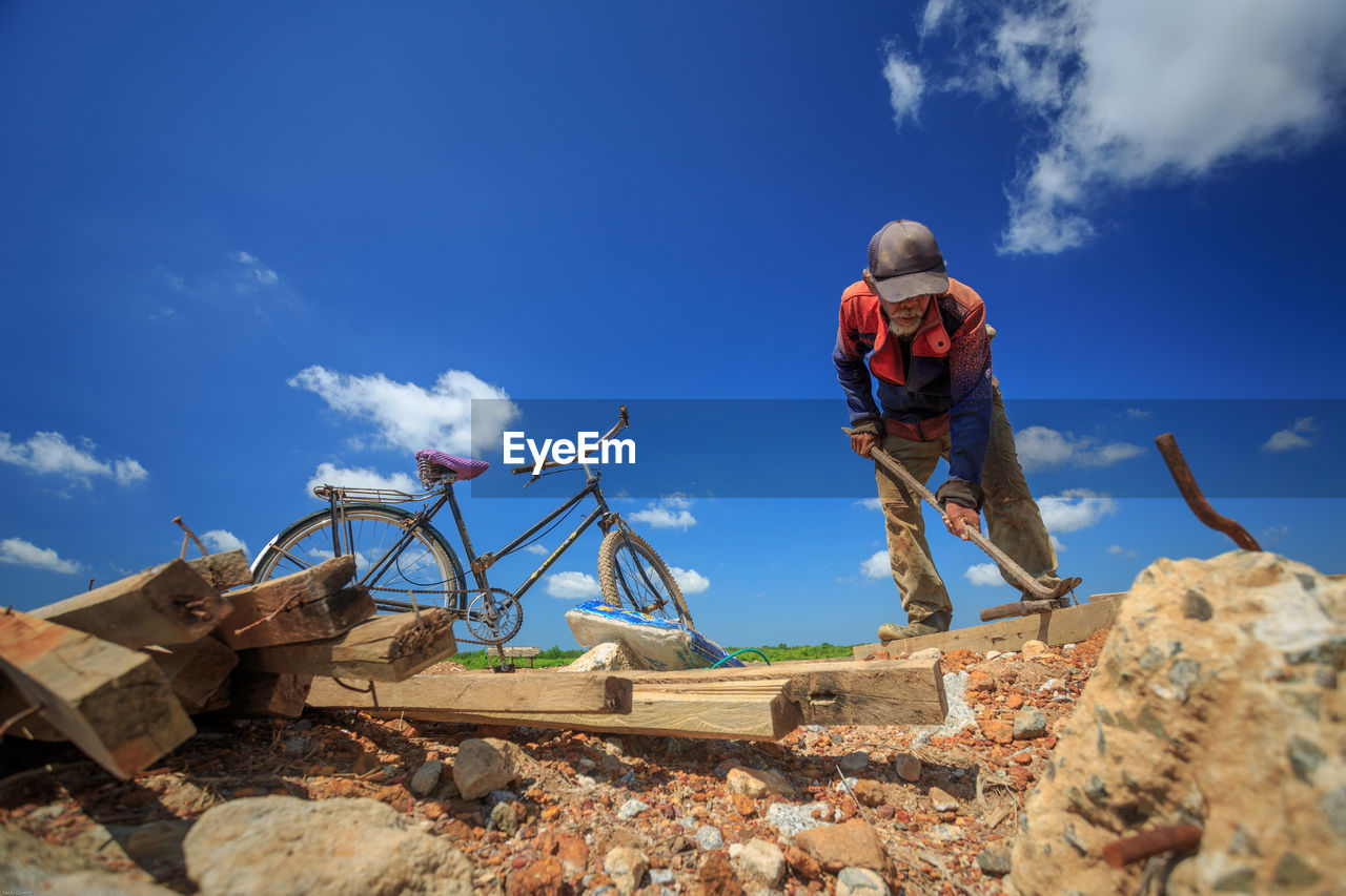 Rear view of man standing against blue sky