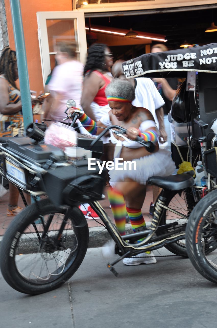 PEOPLE RIDING BICYCLES ON STREET IN CITY