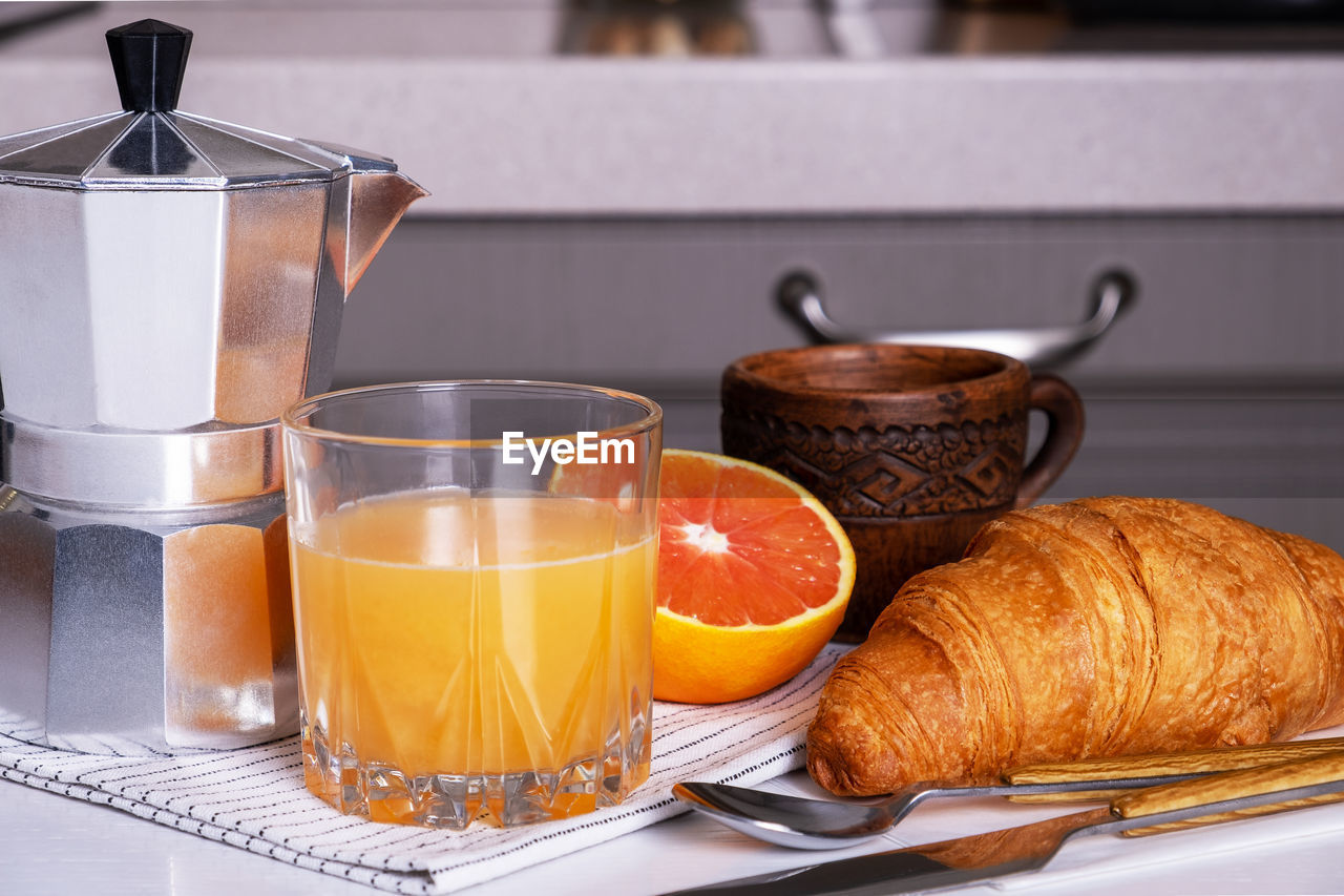Breakfast with coffee, croissant and freshly squeezed orange juice. selective focus.