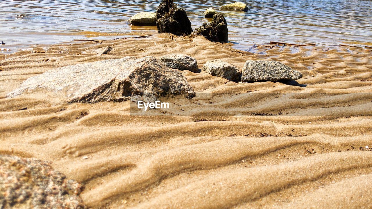 land, beach, water, sand, nature, sea, shore, day, sunlight, tranquility, beauty in nature, no people, coast, outdoors, high angle view, natural environment, scenics - nature, tranquil scene, rippled, rock