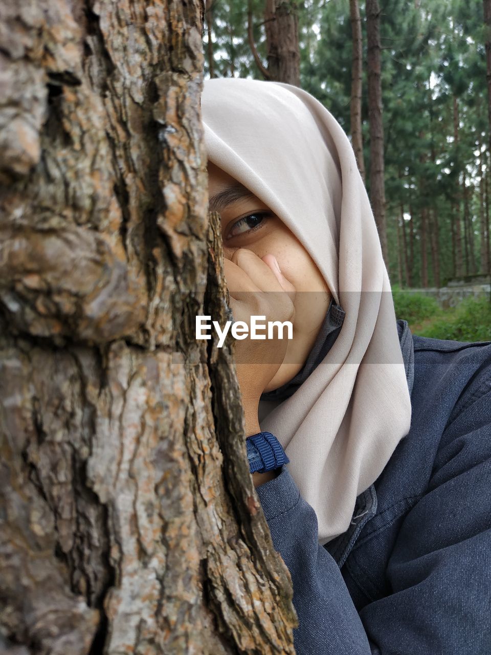 PORTRAIT OF WOMAN IN TREE TRUNK