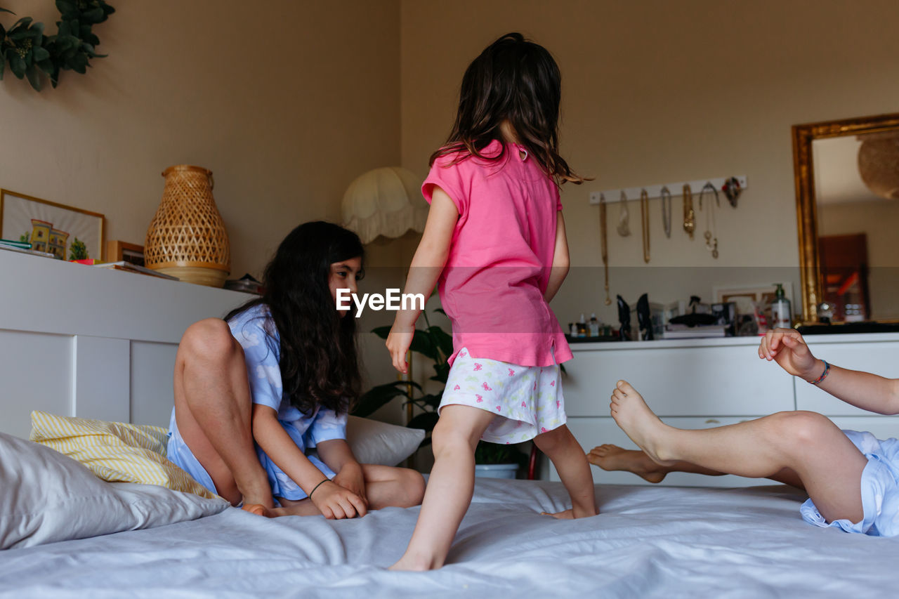 Little girls playing on parents bed at home