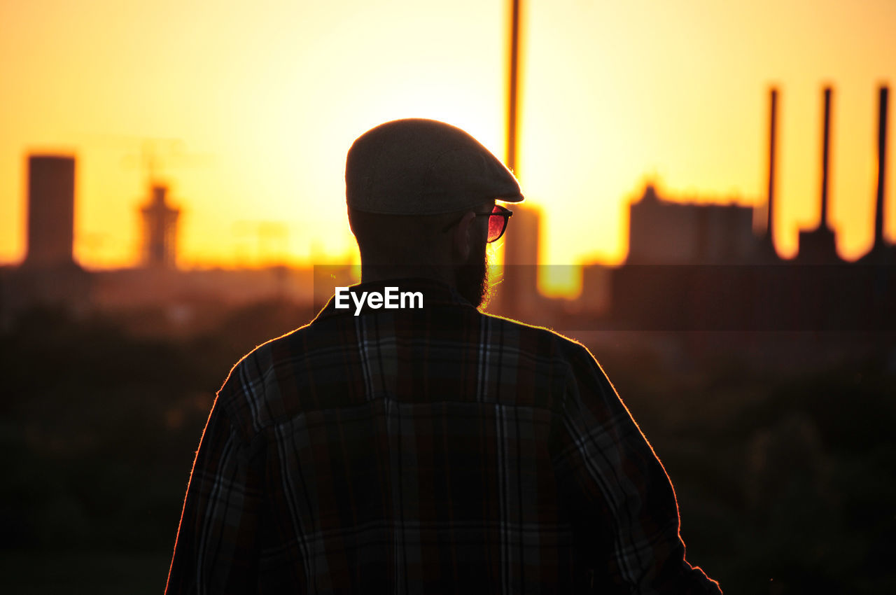 Young man looking into the sunset. 