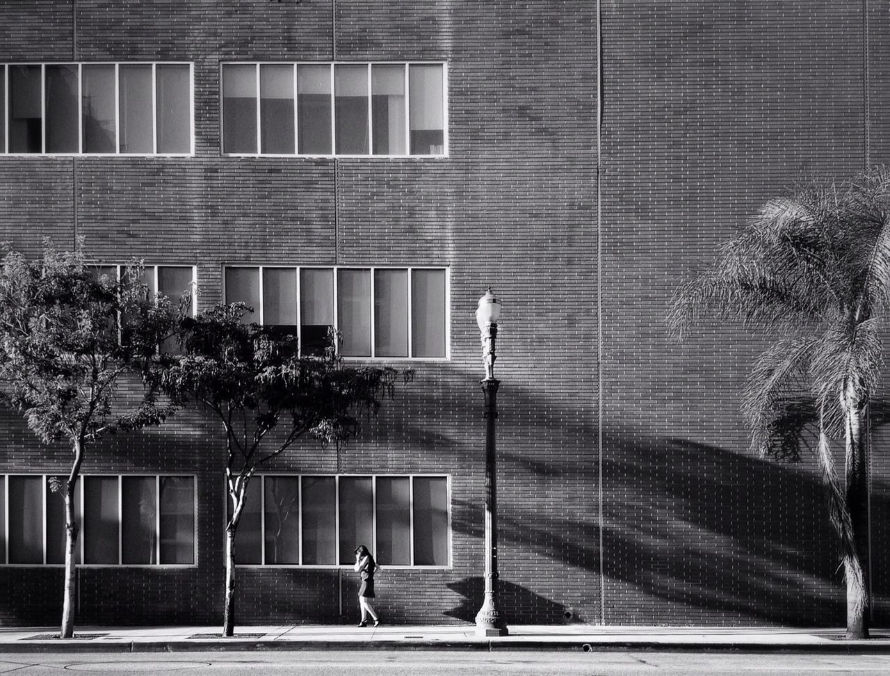 Woman walking on sidewalk by building