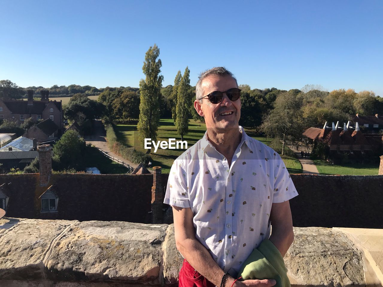 PORTRAIT OF YOUNG MAN WEARING SUNGLASSES STANDING AGAINST SKY