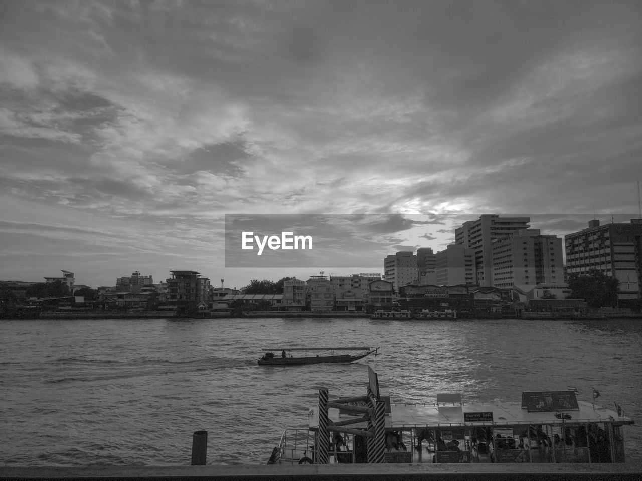 VIEW OF CITYSCAPE BY RIVER AGAINST SKY