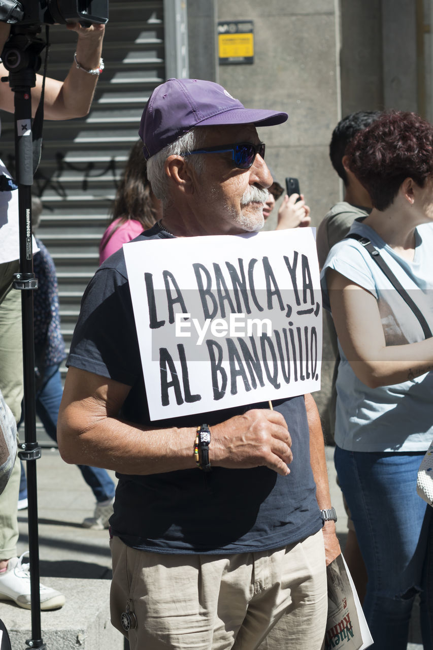 crowd, street, text, protest, adult, architecture, women, person, communication, law, road, city, men, group of people, jeans, standing, clothing, government, social issues, young adult, trousers