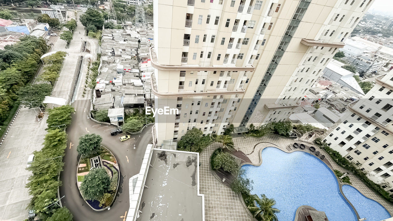 architecture, built structure, city, building exterior, high angle view, aerial photography, bird's-eye view, residential area, neighbourhood, condominium, building, transportation, urban design, day, water, street, nature, road, mode of transportation, aerial view, no people, motor vehicle, plant, estate, car, residential district, outdoors, tree, cityscape, city street, landmark, travel, travel destinations, land vehicle, skyscraper, waterway, tower block, city life