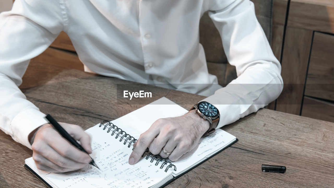 Businessman white shirt reading and signs documents