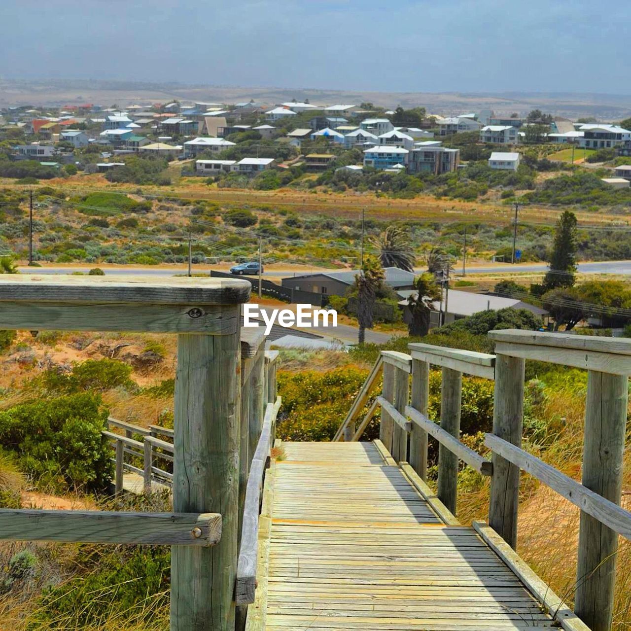 Scenic view of residential district and boardwalk at field