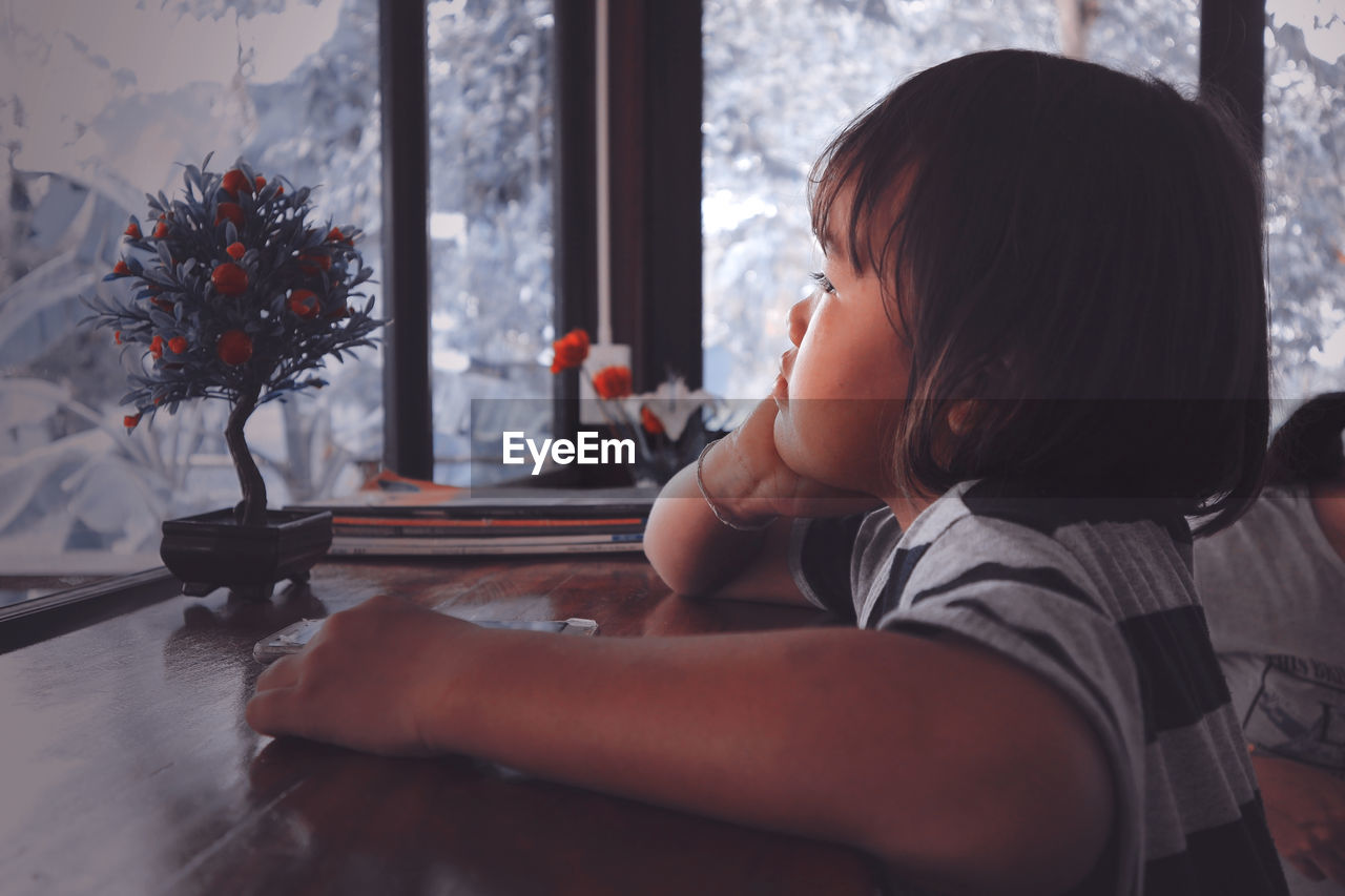 Close-up of cute girl sitting at cafe