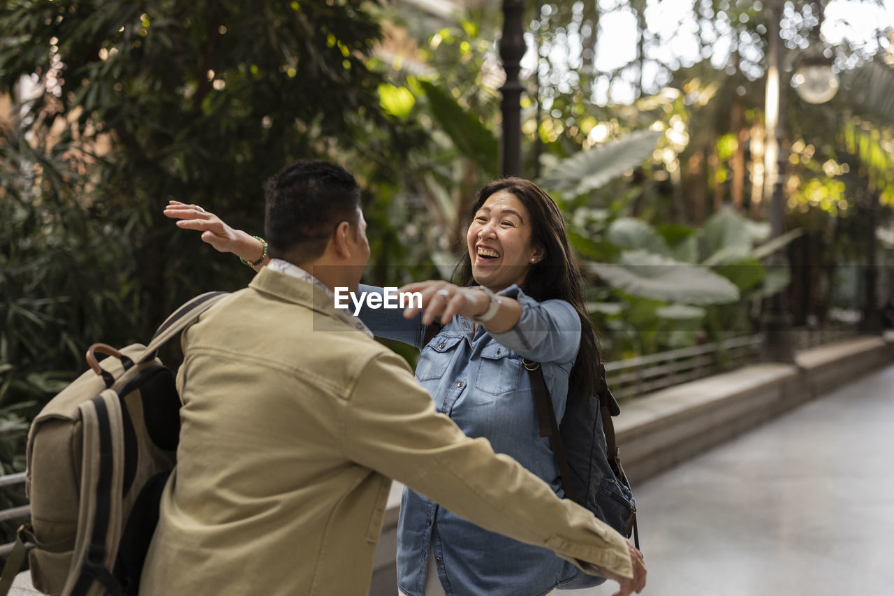 Happy mature woman embracing man on footpath