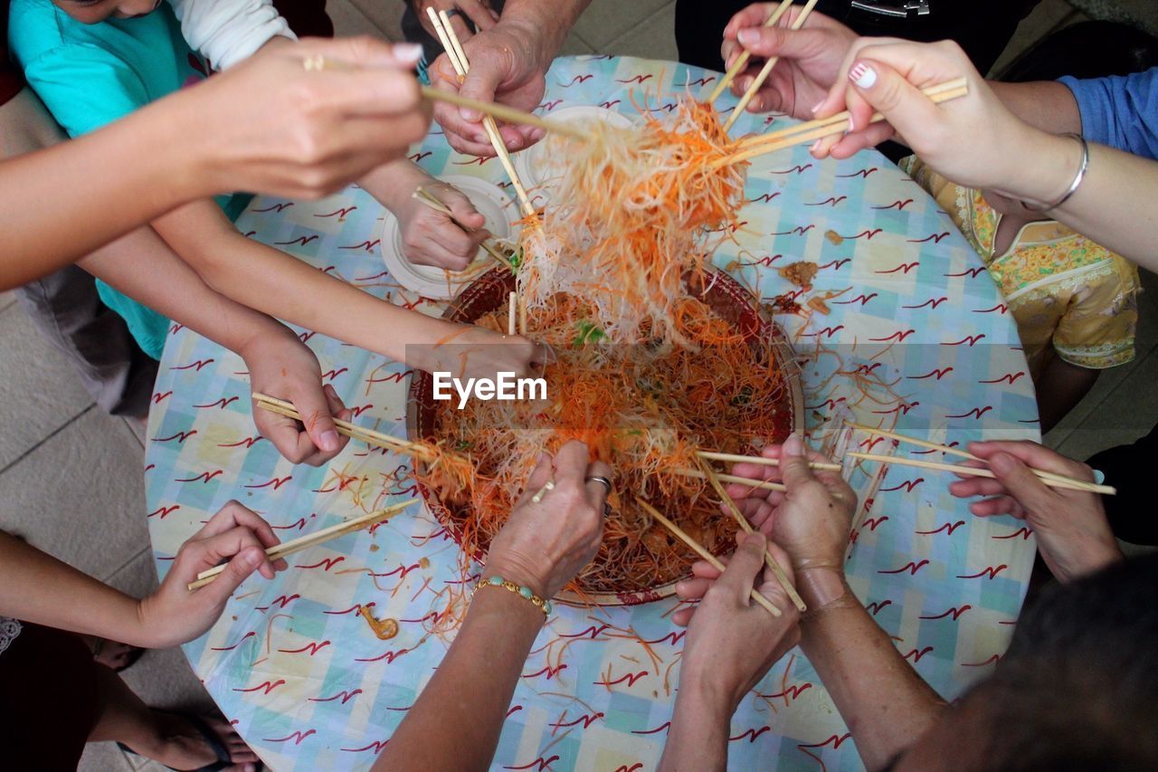 High angle view of people sharing noodles