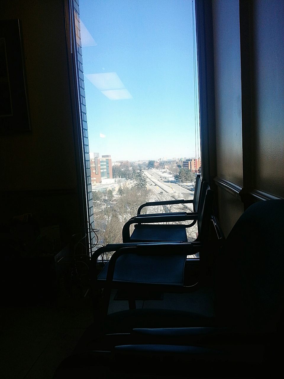 Empty chairs with city view through window
