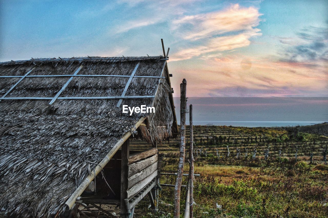 Built structure on land against sky during sunset