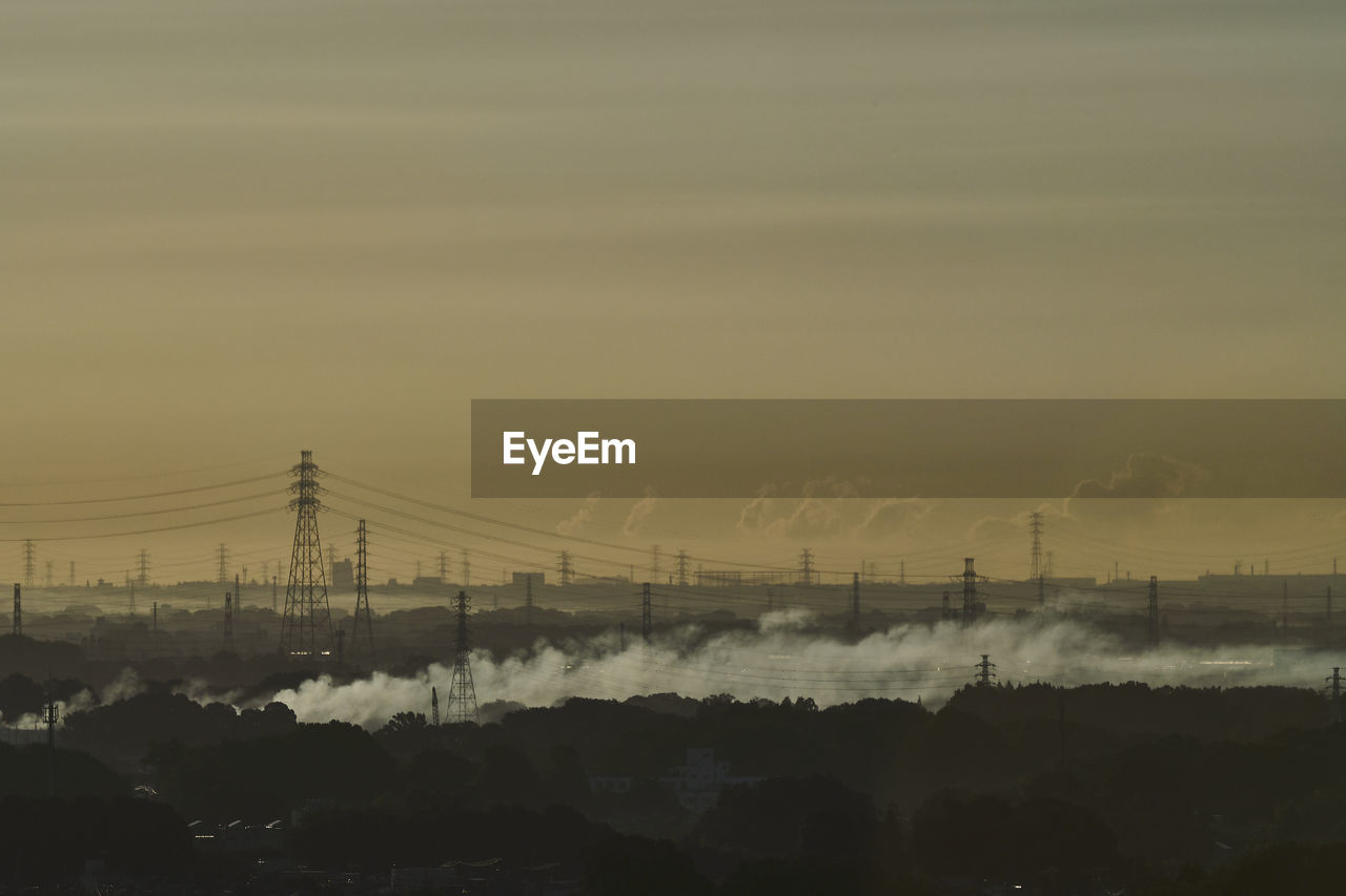 Electricity pylon against sky during sunrise 