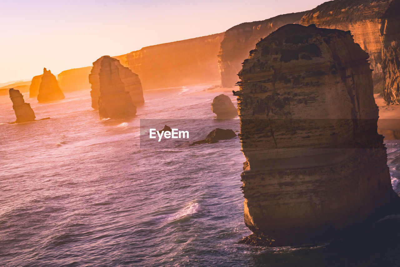 ROCK FORMATION ON SEA SHORE AGAINST SKY