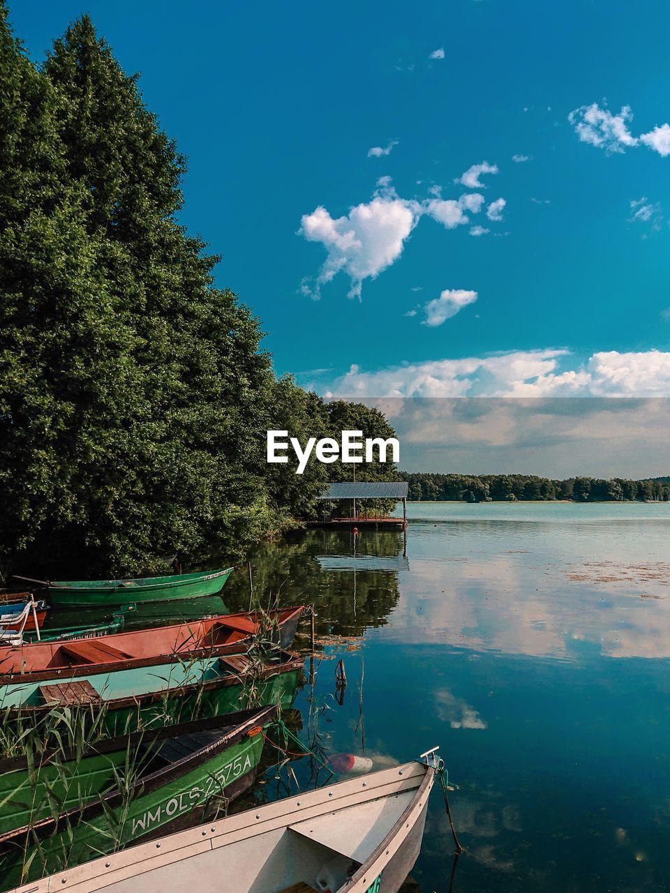 BOATS MOORED BY LAKE AGAINST SKY