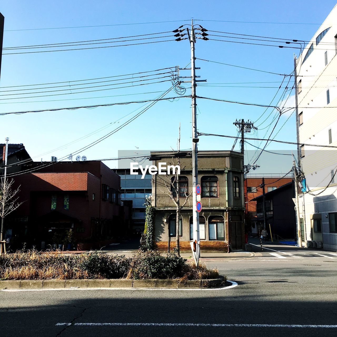 STREET BY BUILDINGS AGAINST SKY