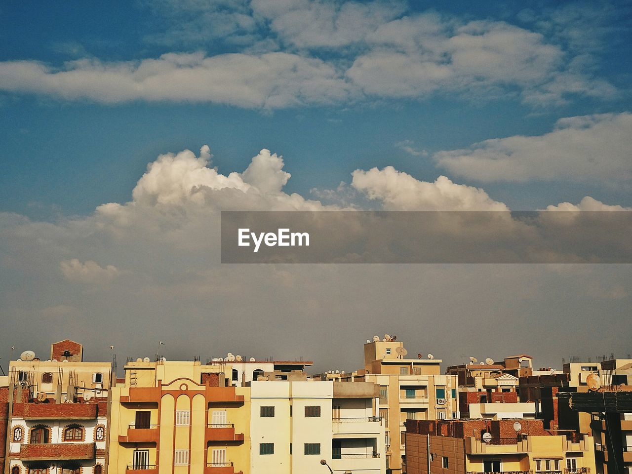 Residential buildings against cloudy sky