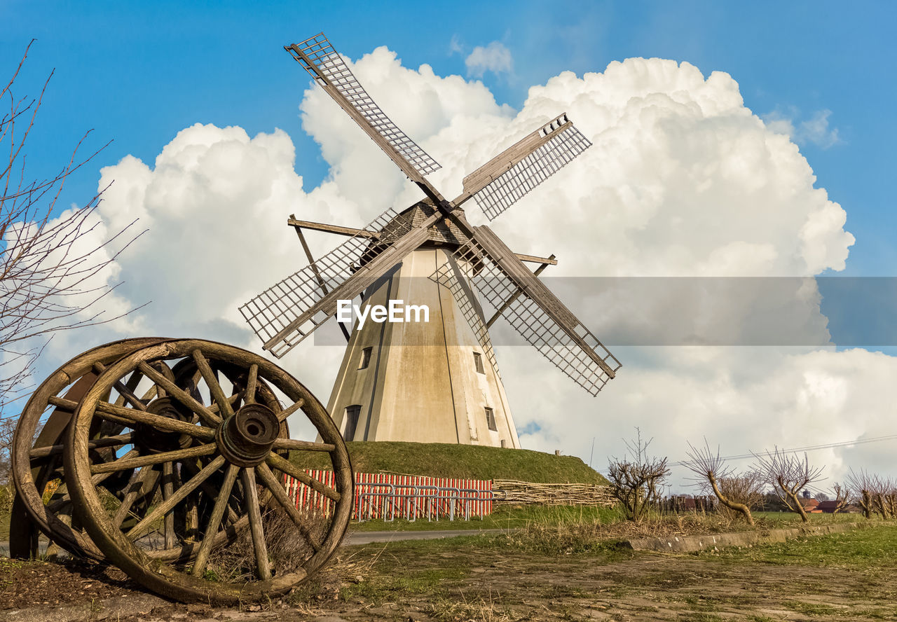 Traditional windmill on field against sky