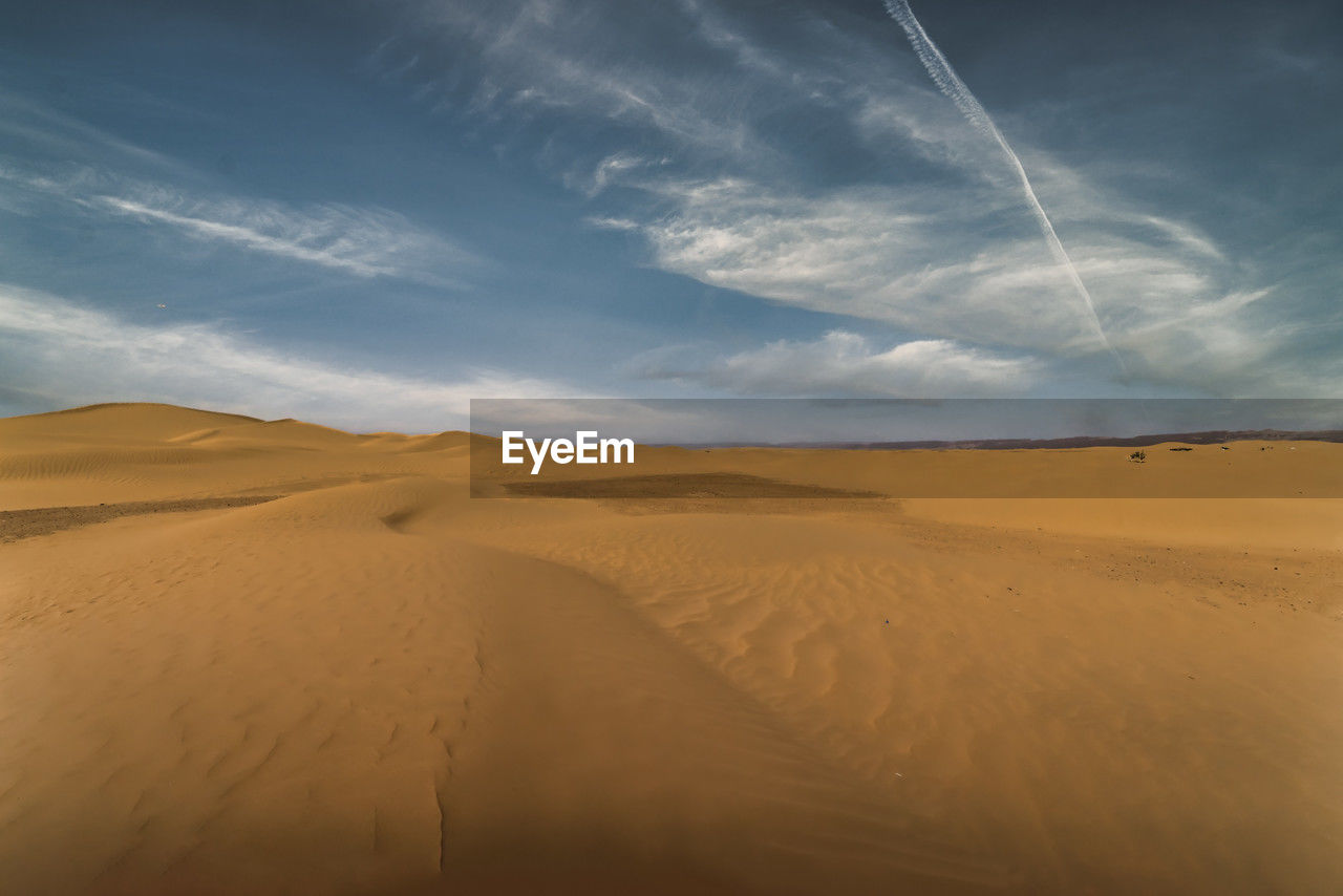 scenic view of desert against blue sky