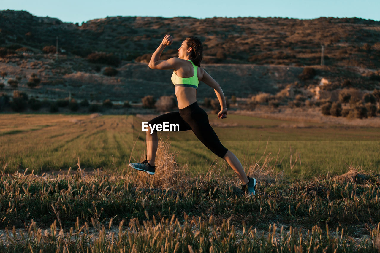 Full length of woman with running on field