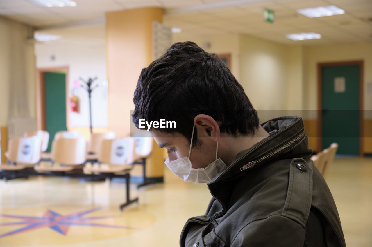 Caucasian boy wearing covid19 mask is waiting for hospital exams