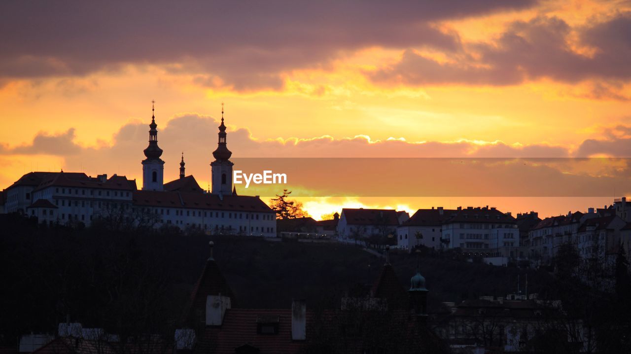 SILHOUETTE OF BUILDINGS AGAINST CLOUDY SKY