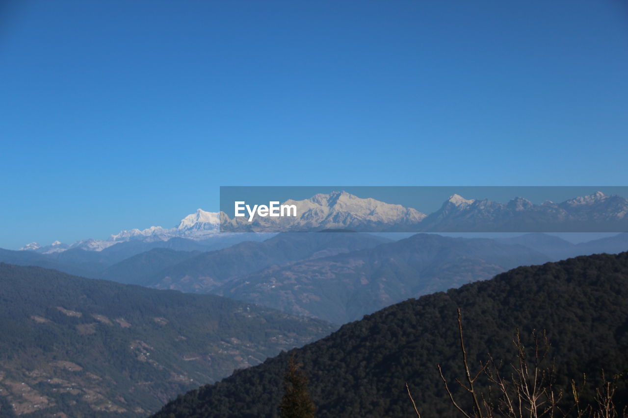 Scenic view of mountains against clear blue sky