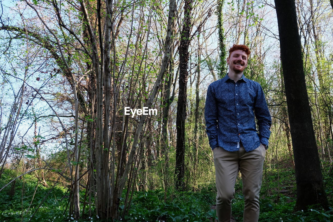 Portrait of smiling man standing in forest