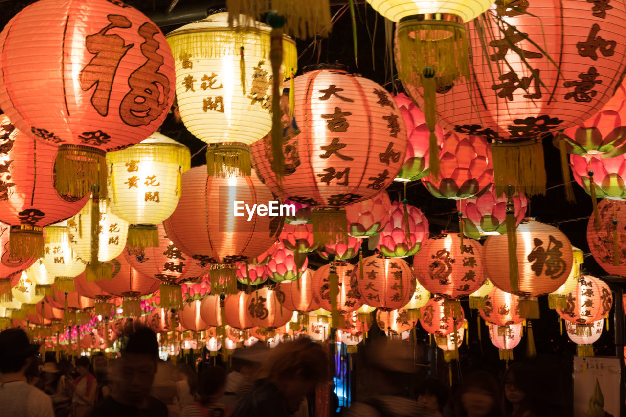 PANORAMIC SHOT OF ILLUMINATED LANTERNS HANGING ON NIGHT