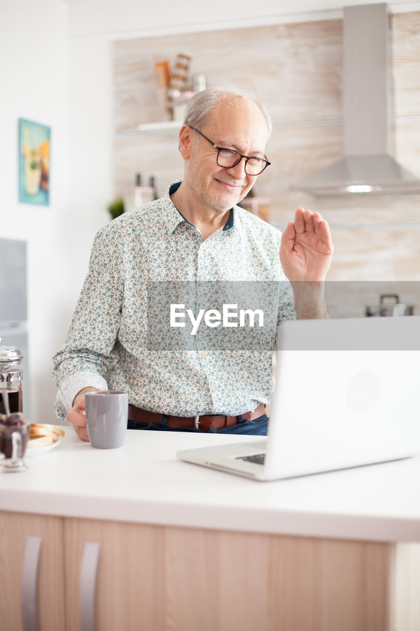 Man using mobile phone while sitting on table