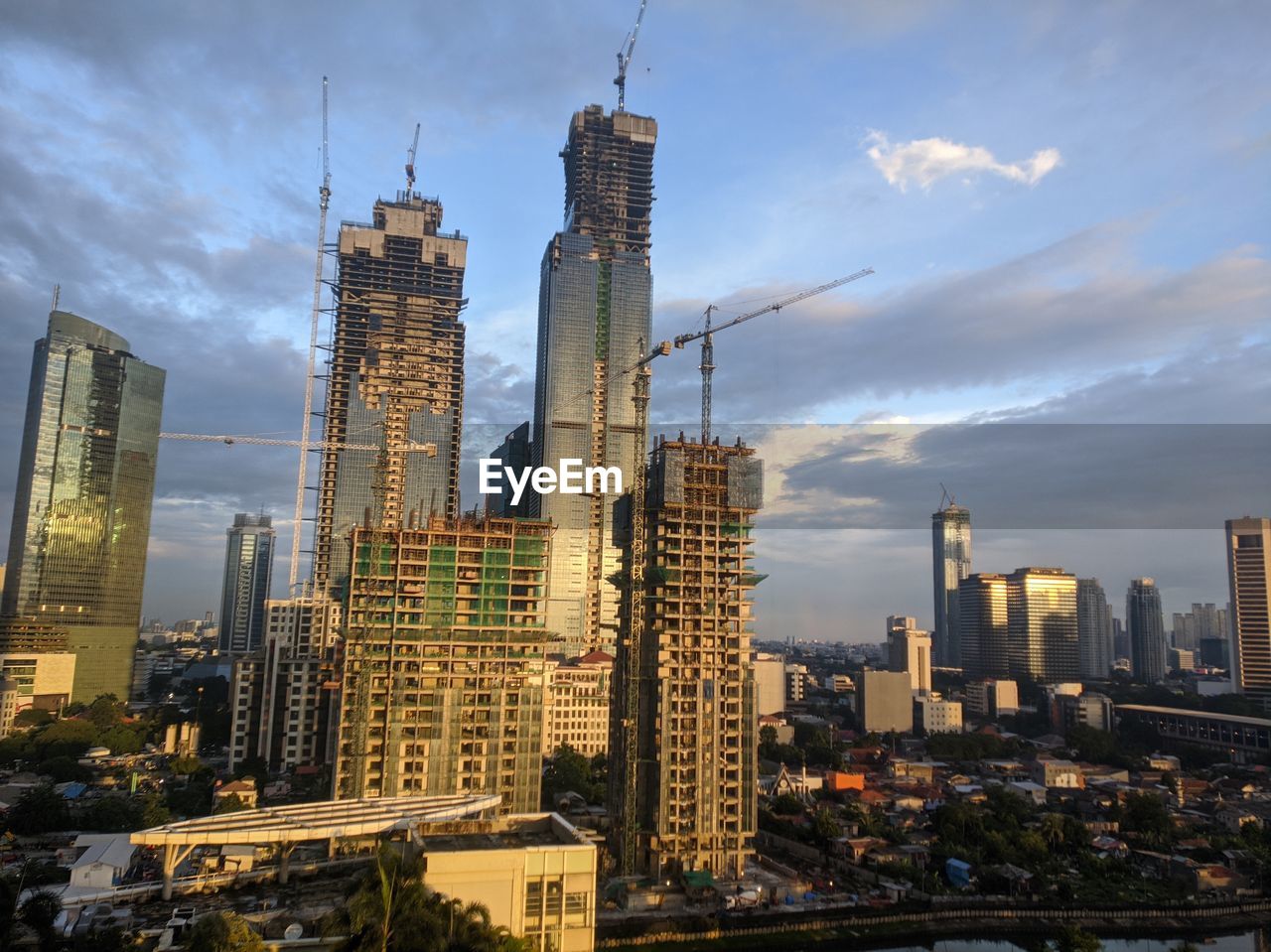 Modern buildings in city against cloudy sky