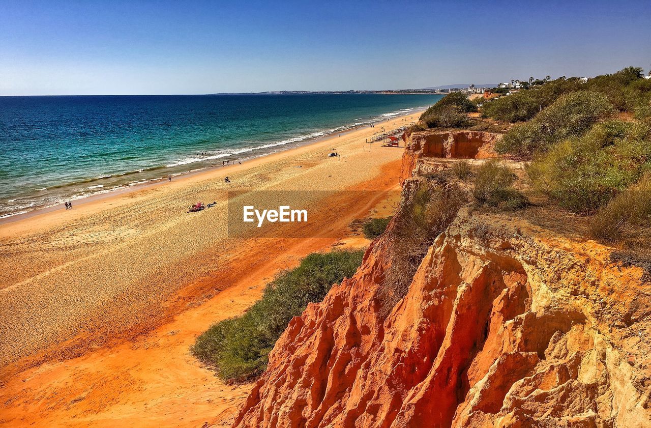 View of calm beach against blue sky