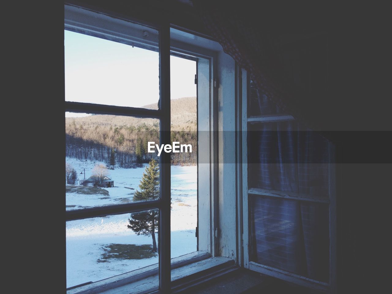 Snow covered field seen through window