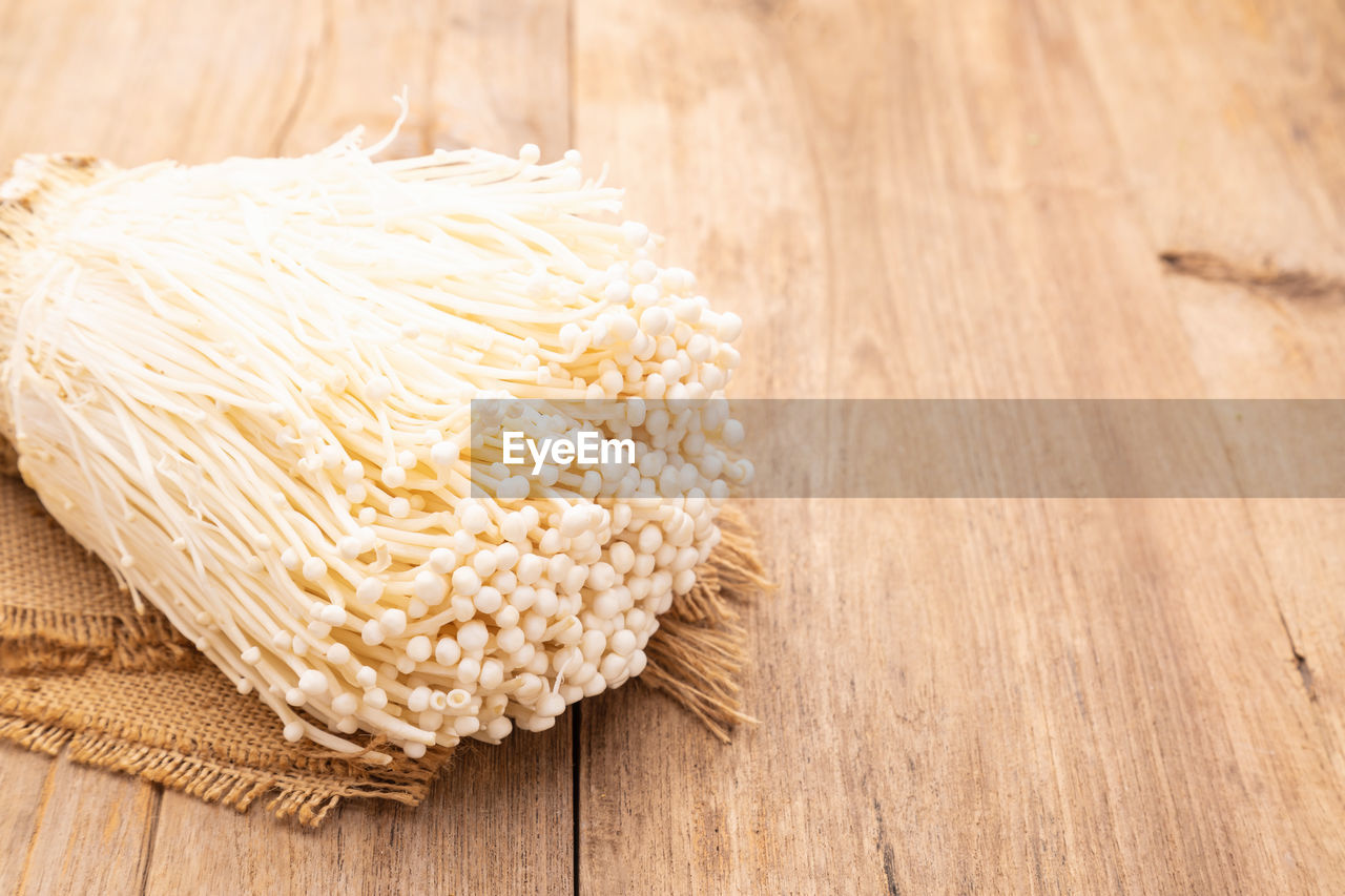 Close up golden needle mushroom on wooden table background. food and healthcare concept