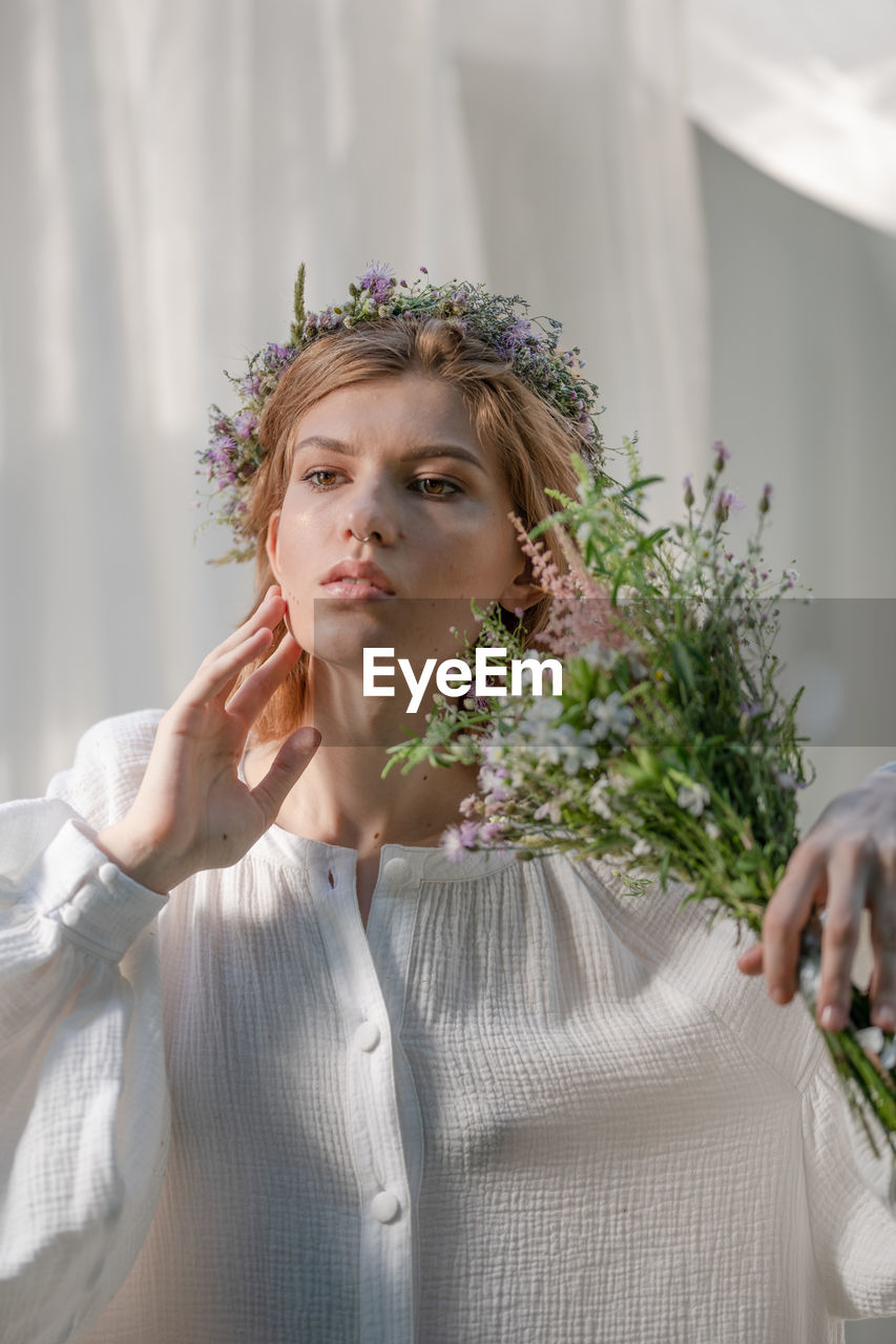 Portrait of a beautiful young woman holding flower bouquet