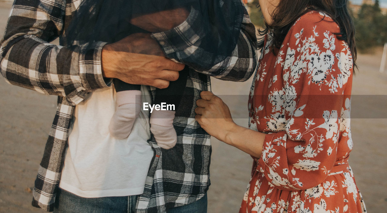 Midsection of couple standing outdoors