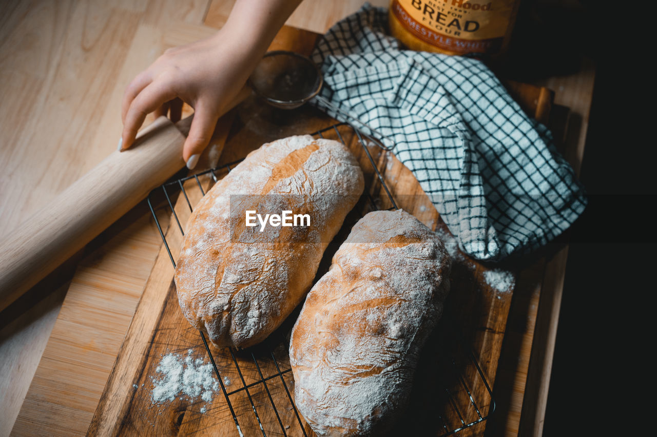 Cropped hand of person preparing food bread homemade