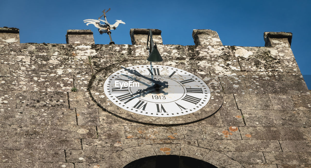 LOW ANGLE VIEW OF CLOCK ON WALL