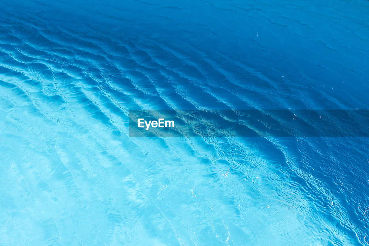 View of surface of turquoise water in swimming pool, sea or ocean, summer background. gradient.