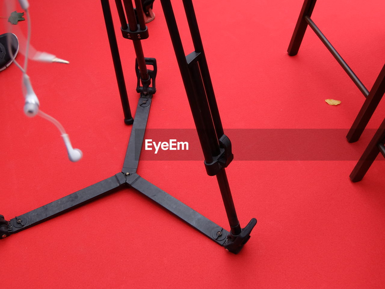 Low section of tripod on red carpet 